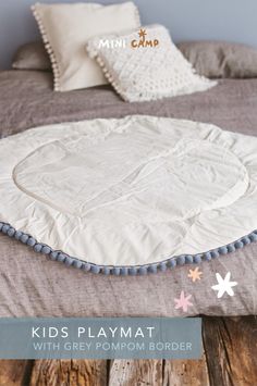 Looking for a stylish addition to your child's nursery? Our MINICAMP Kids Playmat with Grey Pompom Border is perfect! Made from hypoallergenic 100% cotton, this round play mat is safe and soft. It's ideal as a baby gym mat, kids floor rug, or a teepee play mat. The unique grey pompom trim adds a boho touch. Perfect for playrooms, nurseries, and living rooms. Machine washable and certified by Oeko-Tex for safety. Handmade, it fits boho and modern decor styles perfectly. Nursery Decor Inspiration, Cozy Reading Corners, Tent Decorations