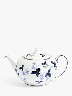 a blue and white teapot with flowers painted on the side, sitting against a white background