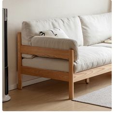 a white couch sitting on top of a hard wood floor next to a wall mounted heater