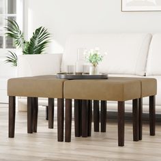 two stools sitting on top of a wooden table in front of a white couch