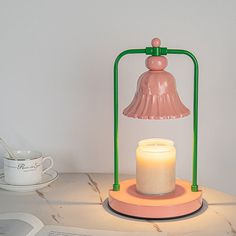 a candle is sitting on a table next to a lamp