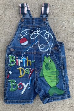 "HandPainted Gone Fishin overalls design perfect lil boy baby outfit for your little guy's birthday. These are such a sweet design. Get his age painted along with the words, \"Birthday Boy!\" down the leg and a fish painted on the bib with a fishing line and bobber. Super cute design! All my designs are painted custom, which means you can change up the colors if you like, change the age, add his name, or have they say something else as well. Not his birthday? I can change that up too and make th Overalls Design, Fishing Themed Birthday Party, Denim Short Overalls, Fishing Birthday Party, Baby Birthday Themes, Short Overalls, Fishing Birthday, First Birthday Themes, Baby Boy 1st Birthday