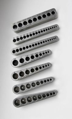 six metal parts are arranged in a row on a white surface with space for text