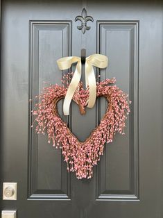 a heart shaped wreath is hanging on the front door to give it a touch of pink