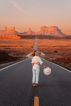 a woman standing on the middle of an empty road