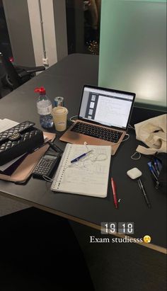 an open laptop computer sitting on top of a desk next to a calculator