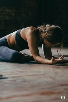 a woman is laying on the floor using her cell phone and looking down at her stomach