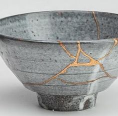 a gray and gold bowl sitting on top of a table