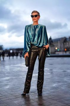 a woman wearing black leather pants and a green blouse