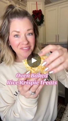 a woman holding up a piece of food in her hands with the words oven baked rice krispy treats