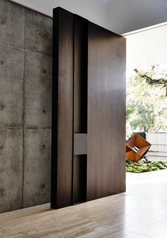 an open door leading into a room with concrete walls and floor to ceiling glass doors