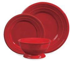 red dinnerware set on white background with place setting in the middle and bowl at the bottom