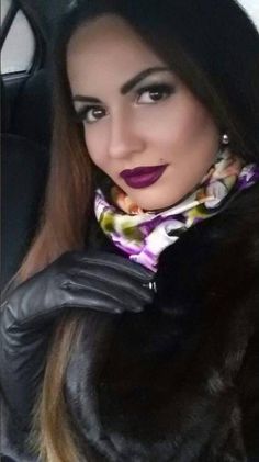 a woman in a car wearing a scarf and gloves