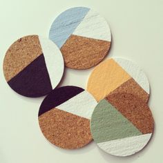 four coasters made out of cork with different colors and shapes on the top one