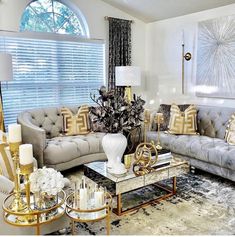 a living room with couches, chairs and lamps in front of a window filled with curtains