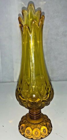 a yellow glass vase sitting on top of a table