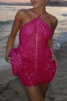 a woman in a pink dress on the beach