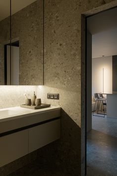 a bathroom sink sitting under a mirror next to a wall mounted faucet with lights on it