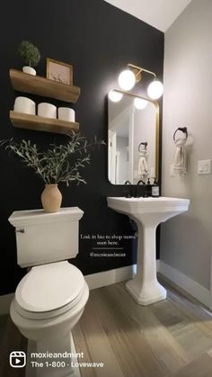 a white toilet sitting next to a sink in a bathroom under a mirror and lights