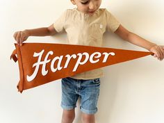 a young boy holding up a sign that says harper