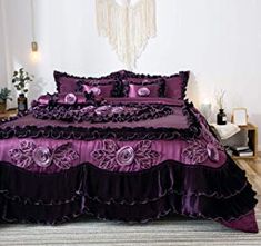 a bed with purple comforter and pillows in a room