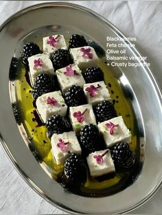 there are many pieces of cake on the plate with blackberries and raspberries