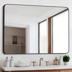 a bathroom sink with a large mirror over it's top and two faucets on the side