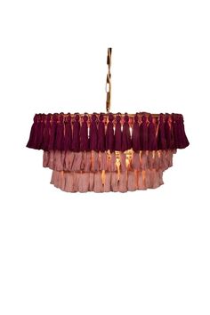 a chandelier hanging from the ceiling with red tassels and gold trim