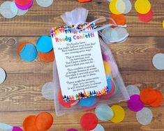 a bag filled with birthday confetti sitting on top of a wooden table next to colorful paper circles