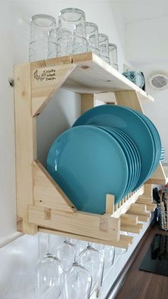 a wooden rack with plates and glasses in it