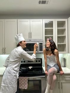 a man and woman dressed as chefs in the kitchen