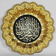 an arabic calligraphy on a gold plate with black and white writing in the middle