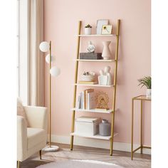 a living room with pink walls and gold shelving unit in the corner next to a white chair