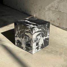 a black and white marble cube sitting on the ground