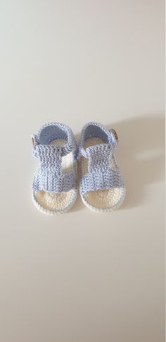 a pair of baby shoes sitting on top of a white floor next to a wall