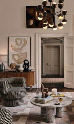 a living room filled with lots of furniture and art on the wall above it's doorway