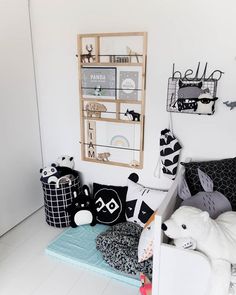 a white room with black and white decor on the walls, stuffed animals and other items