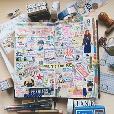 an open notebook with lots of stickers and magnets on it next to other items