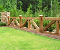 a wooden fence in the middle of a grassy area