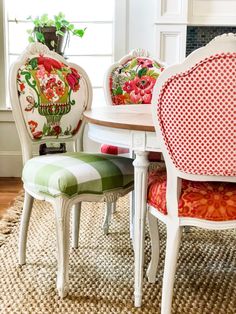 a dining room table with two chairs and a potted plant