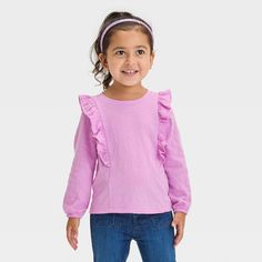 Spruce up your little one’s warm-weather closet with this Long-Sleeve T-Shirt from Cat & Jack™. Crafted from drop-needle, cotton-blend fabric with just the right amount of spandex, this long-sleeve tee offers all-day flexible comfort that moves with them. Ruffle detailing along the shoulders and waist adds depth to the overall look, while the purl-edge hem lends sweet style. Pair with a variety of their fave shorts or pants to create comfy, versatile outfits. Cat & Jack™: Designed for all childr Versatile Outfits, Knit Long Sleeve, Sweet Style, Knitted Tshirt, Toddler Girl Outfits, Girls Long Sleeve, Basic Tees, Toddler Outfits, Warm Weather