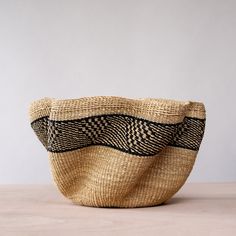 a woven basket sitting on top of a wooden table