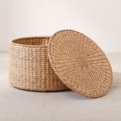 two woven baskets sitting next to each other on top of a white surface with one empty basket in the middle