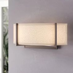 a wall light that is mounted to the side of a wall with a lamp on it