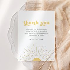 a thank you card sitting on top of a white plate