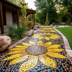 a walkway made out of mosaic tiles with sunflowers painted on the side and rocks