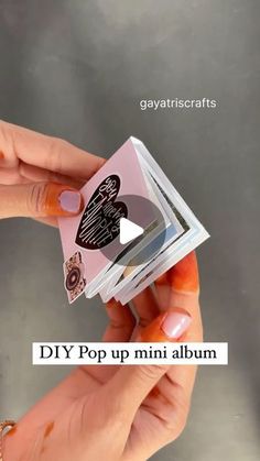 a person holding up a small piece of paper with the words diy pop up mini album on it