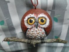 an owl figurine sitting on top of a tree branch