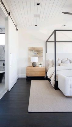 a white bed sitting in the middle of a bedroom