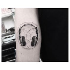 a person with headphones on their arm is wearing a black and white tattoo design